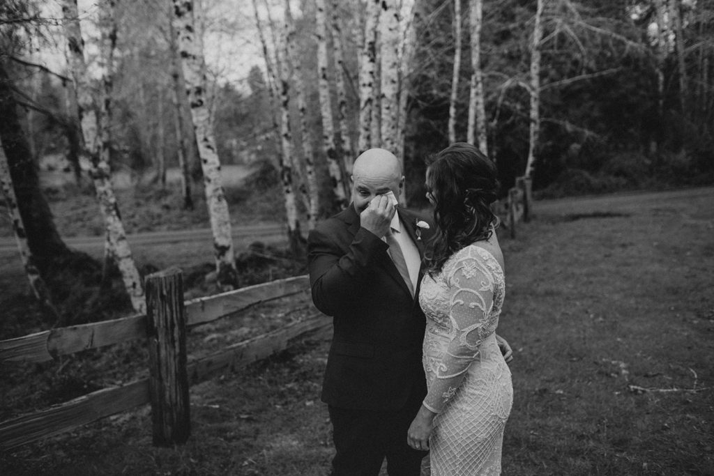 rain forest elopement first look groom wipes tears from eyes after seeing his bride for the first time