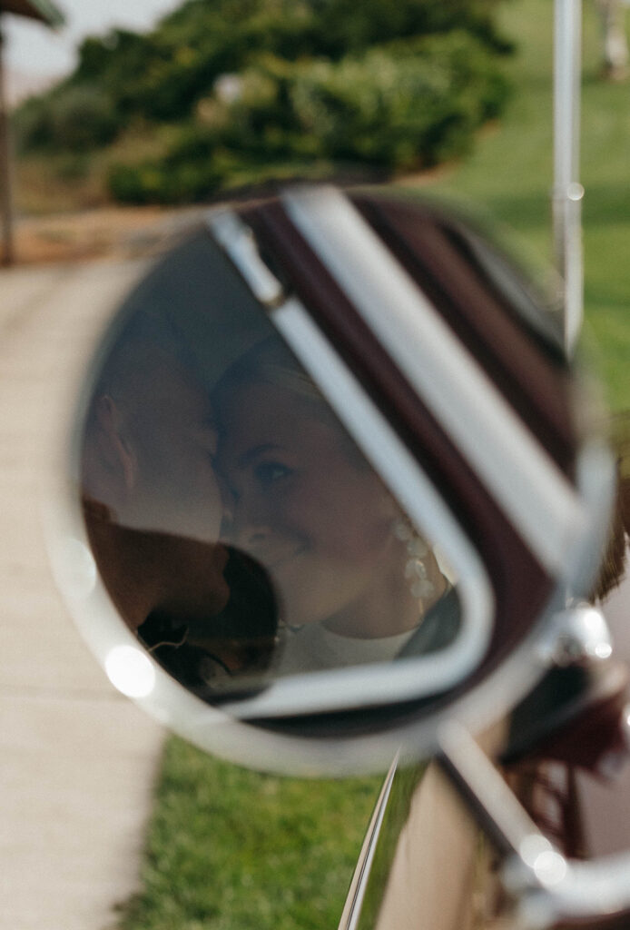 Picture of a couple in a rearview mirror of a vintage car during their engagement session.