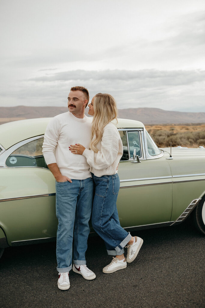 Couple standing by a vintage car during Royal city engagement session portrait.