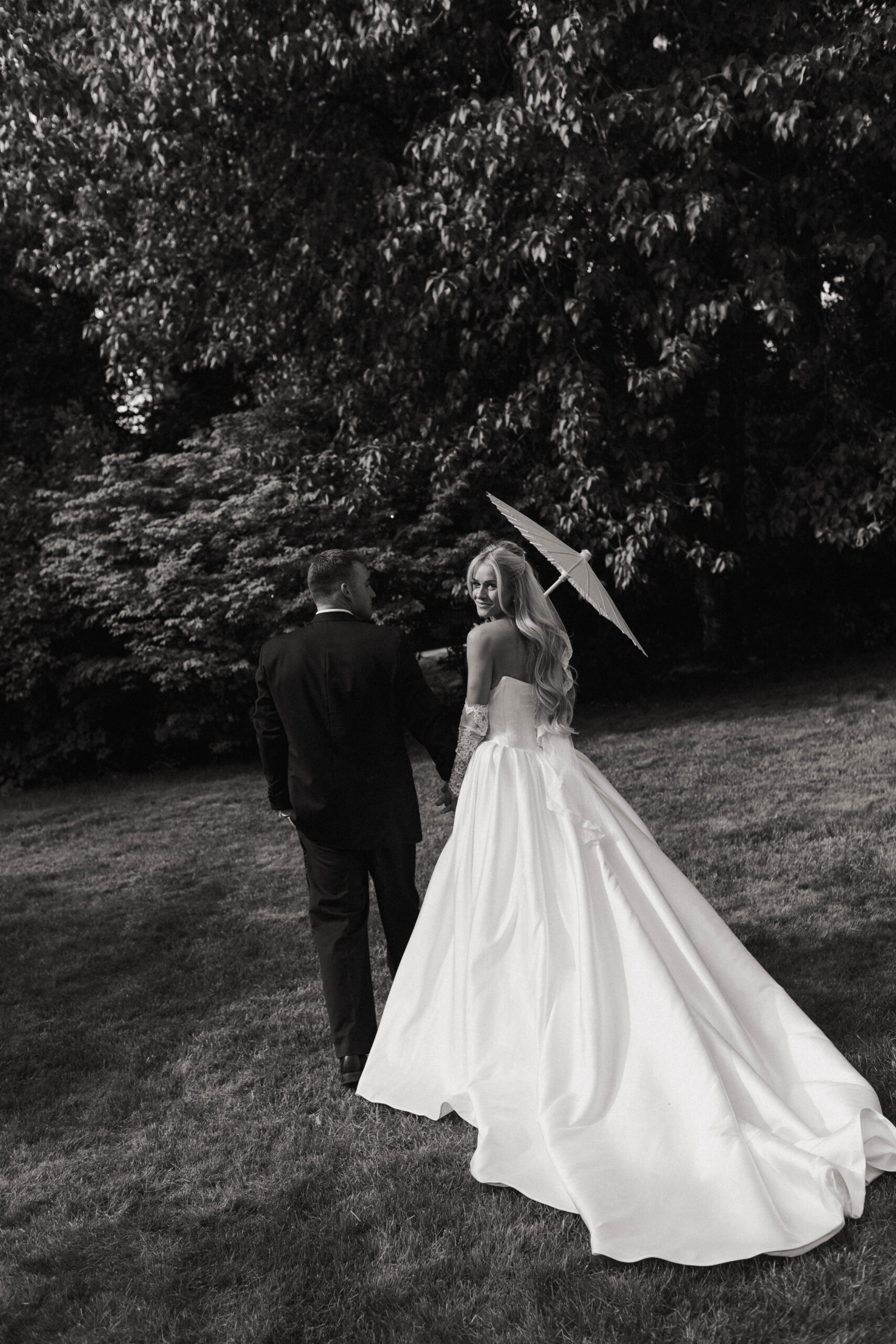 a black and white image of wedding couple walking
