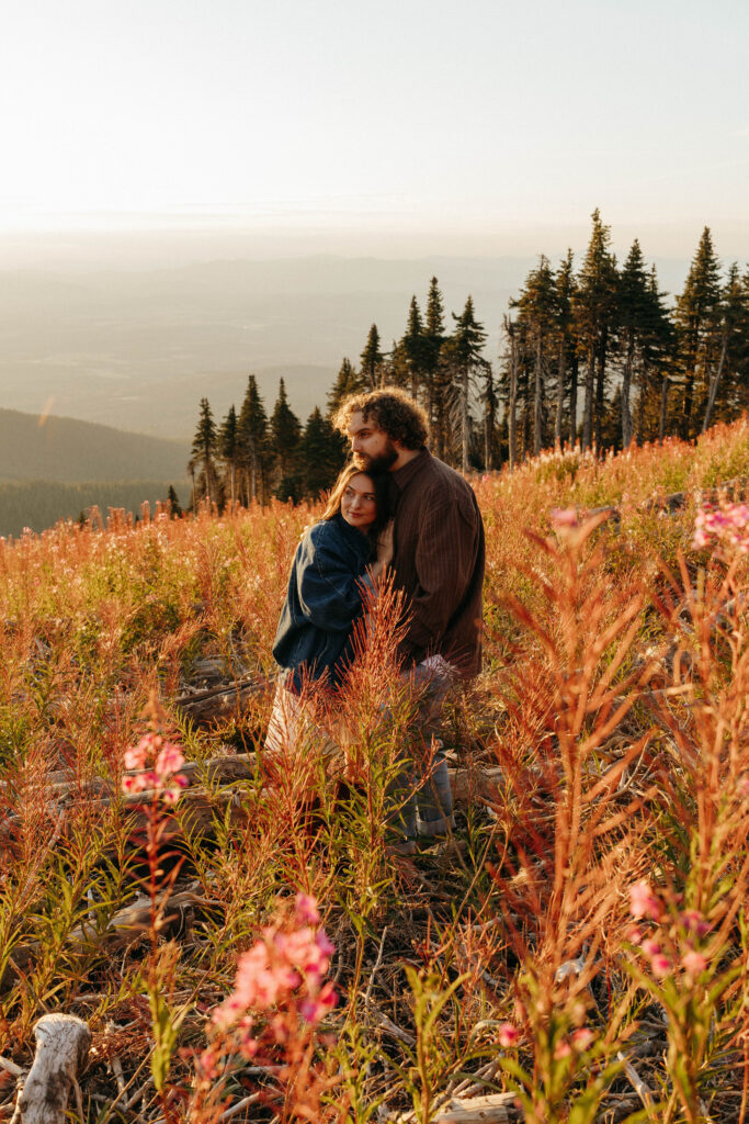 couple on top of mt. spokane enjoying the sunset for their engagement session